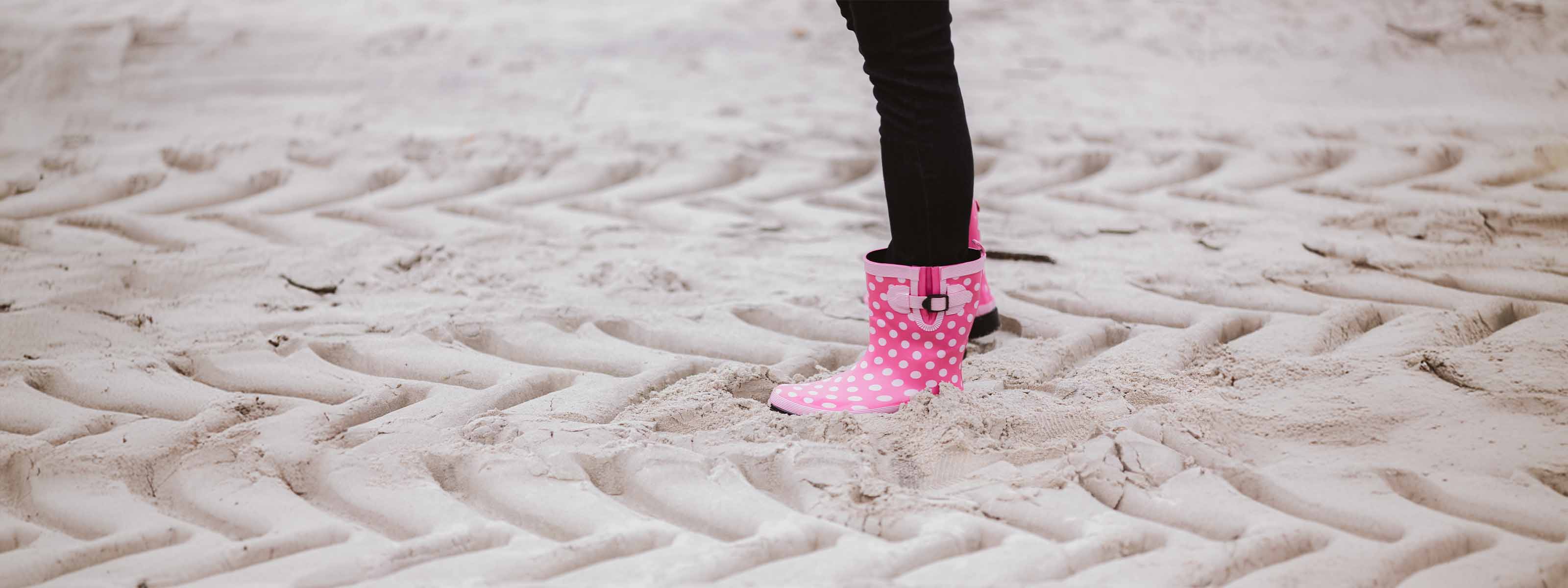 Pinker Gummistiefel am Strand